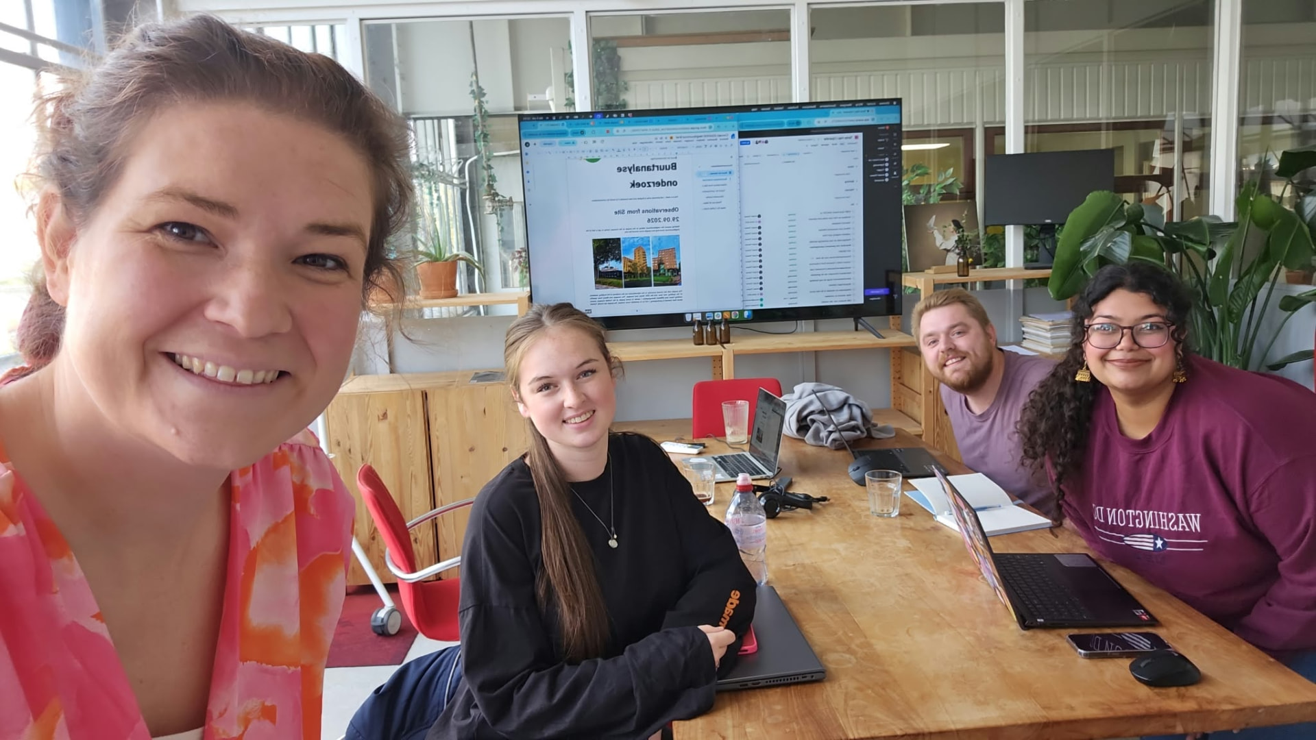 Het team van Tante Hap aan het werk achter een lange houten tafel