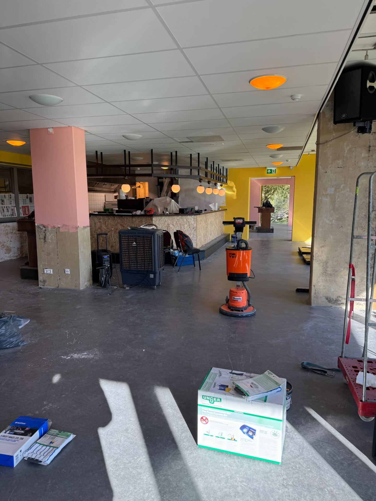 De ruimte van Tante Hap onderweg naar een nieuwe look met een roze pilaar en gele wand